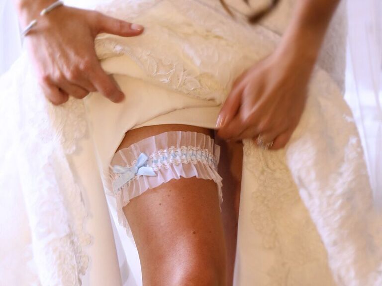 White girdle put on a leg of a bride shortly before the wedding