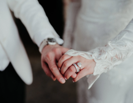 Couple holding hands on wedding day