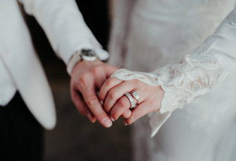 Couple holding hands on wedding day