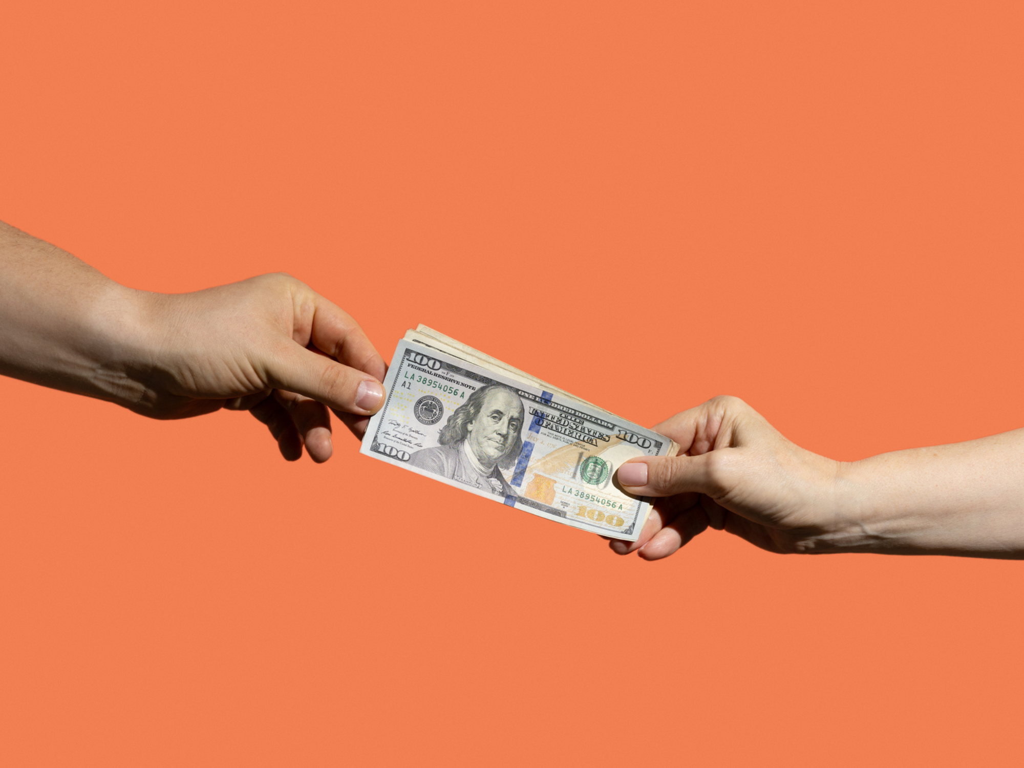 Two hands holding on to money