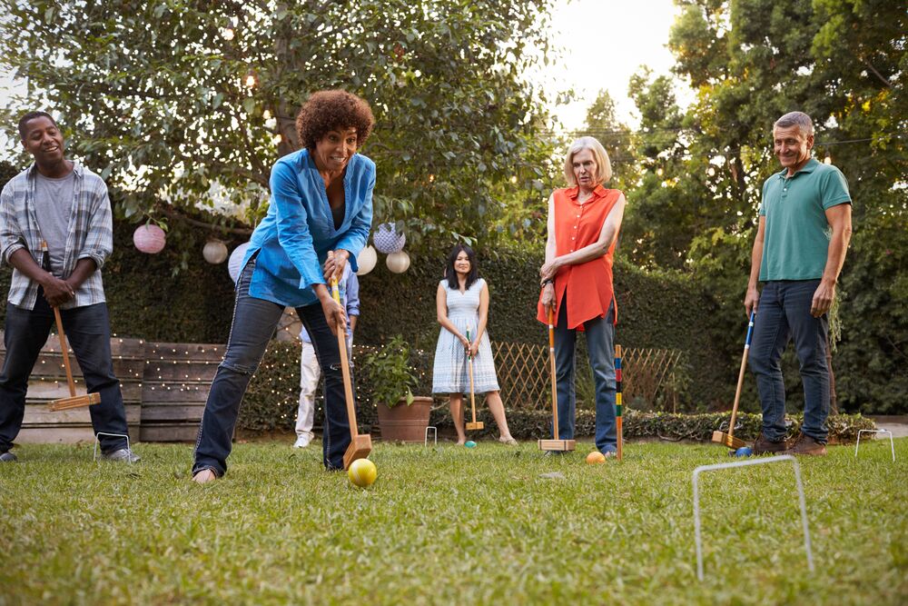 group of people playing cricket outside