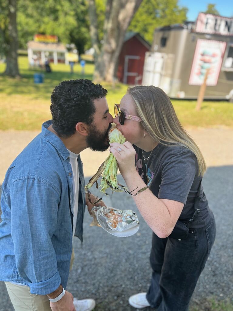 Sharing corn on the cob at a pumpkin patch.