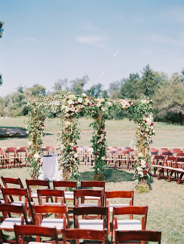 Greenery-covered chuppah surrounded by wood folding chairs.