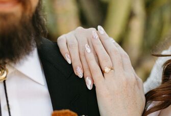 Bride wearing engagement ring with groom