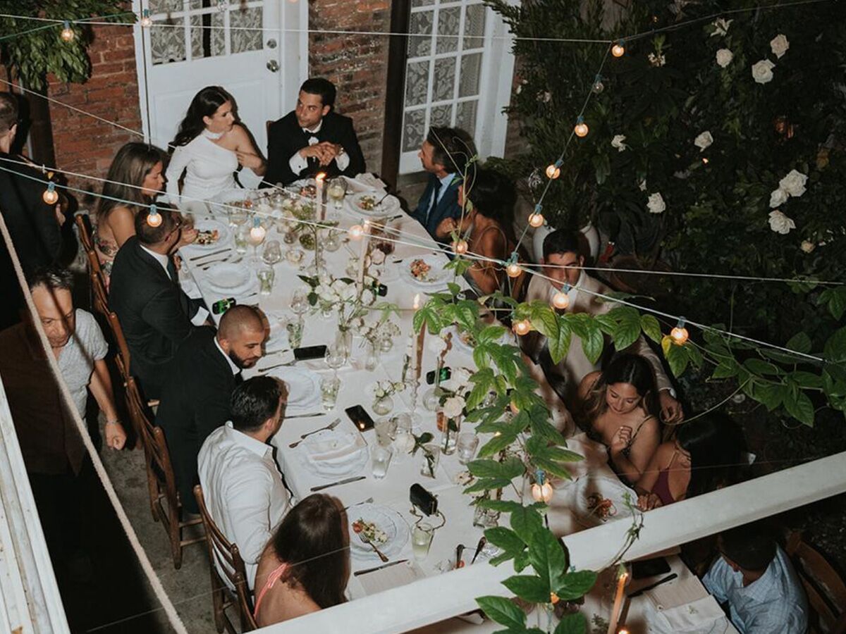 Wedding guest and couple gathered at table for wedding dinner party
