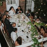 Wedding guest and couple gathered at table for wedding dinner party