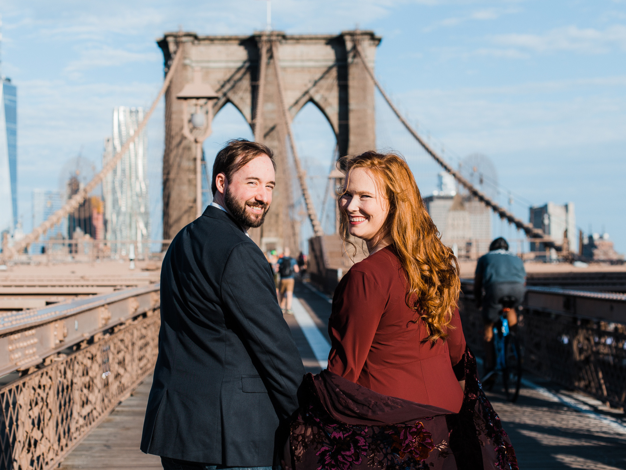 Couple holding hands walking on Brooklyn Bridge in NYC