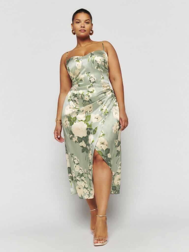 Model wears sage green floral silk dress