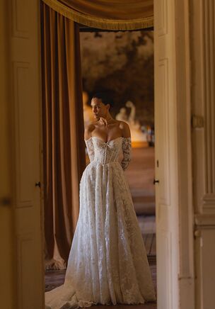 Fortuna is an A-line silhouette gown, crafted from delicate lace and shimmering Chantilly lace with sequins. Sheer long sleeves, made from the same intricate lace, are fastened with discreet hidden zippers at the cuffs, offering a refined and seamless finish. The traditional lace-up corset provides both structure and flexibility, ensuring a flattering fit for every bride. The chapel-length train is gracefully adorned with lace that gently scatters toward the hem, creating a romantic effect as the bride walks. A perfect choice for those seeking timeless beauty with a subtle touch of glamour.