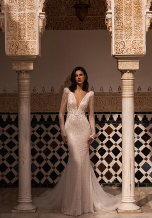Introducing our exquisite mermaid wedding dress, a true masterpiece of elegance and allure. Every detail of this dress is meticulously crafted to create a stunning ensemble that will leave you and your guests in awe. The entire silhouette is adorned with intricate beadwork, pearls, and floral lace, creating a mesmerizing display of texture and artistry. The deep V-neckline adds a hint of sensuality, while the long sleeves exude an air of sophistication and grace. As you move, the dress shimmers and glimmers, capturing the light and casting a spellbinding glow. The mermaid silhouette hugs your curves, accentuating your natural beauty and creating a silhouette that is both statuesque and enchanting.