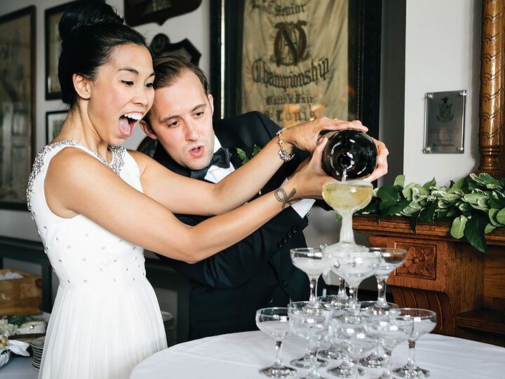 Bride and groom with their champagne tower on their wedding day