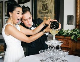 Bride and groom with their champagne tower on their wedding day