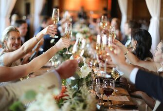 guests toasting with champagne glasses seated at a table