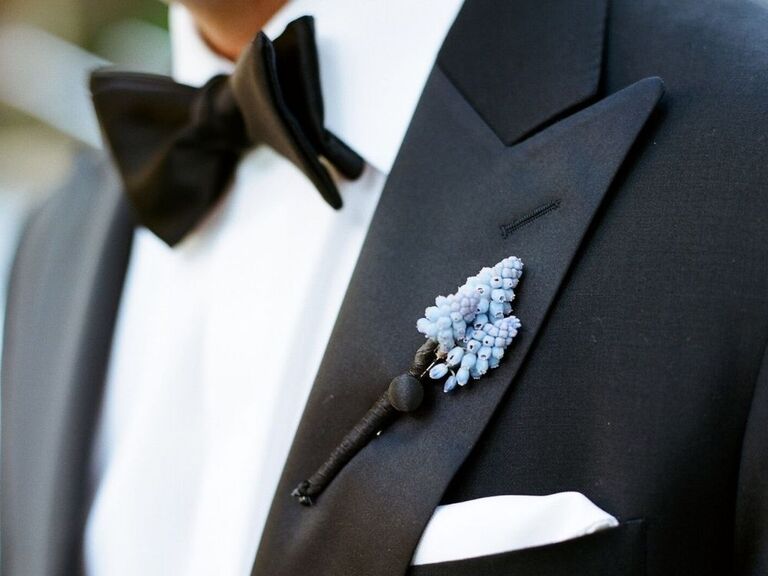A blue muscari boutonniere on a black tux lapel