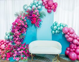 Pink and blue balloon bridal shower backdrop with white couch