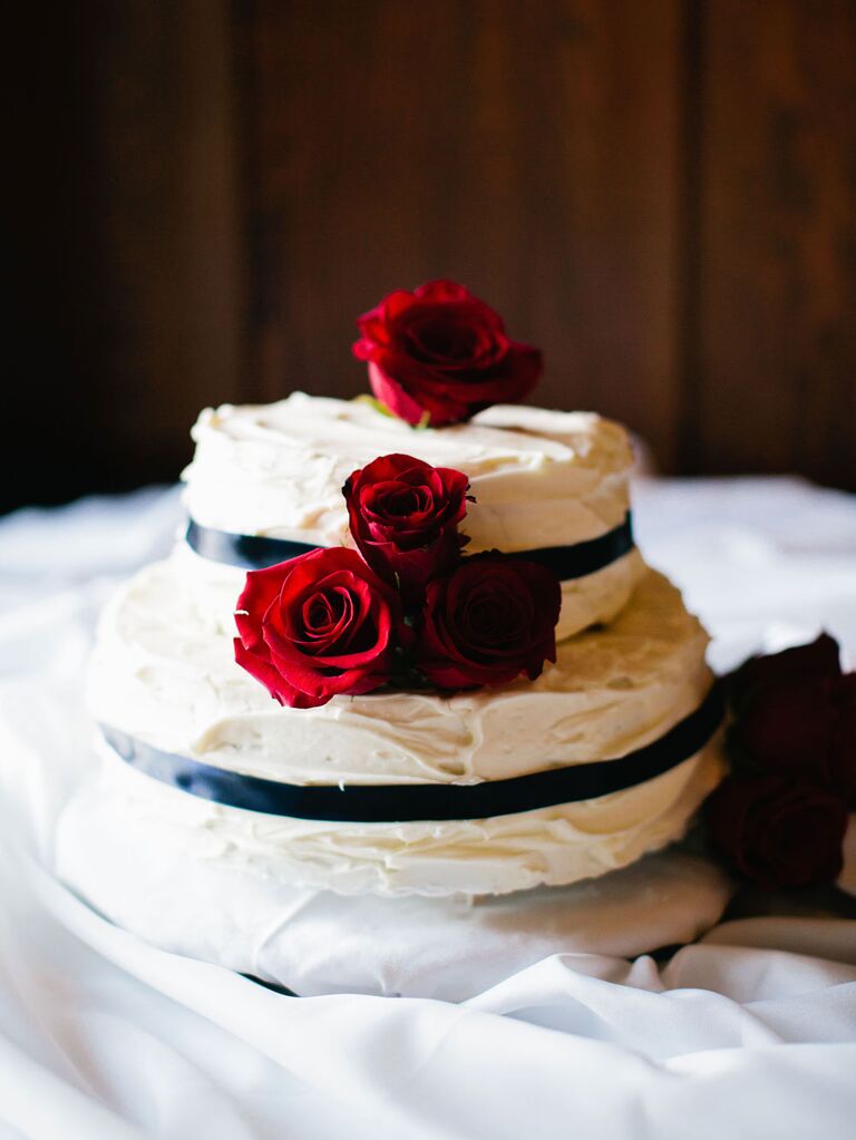 Two tier black and white fondant cake, decorated with a few bright red  roses to complete the look 🌹 💝credit to original artist/baker .…