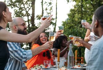 joint bachelor/bachelorette party toasting drinks outdoors