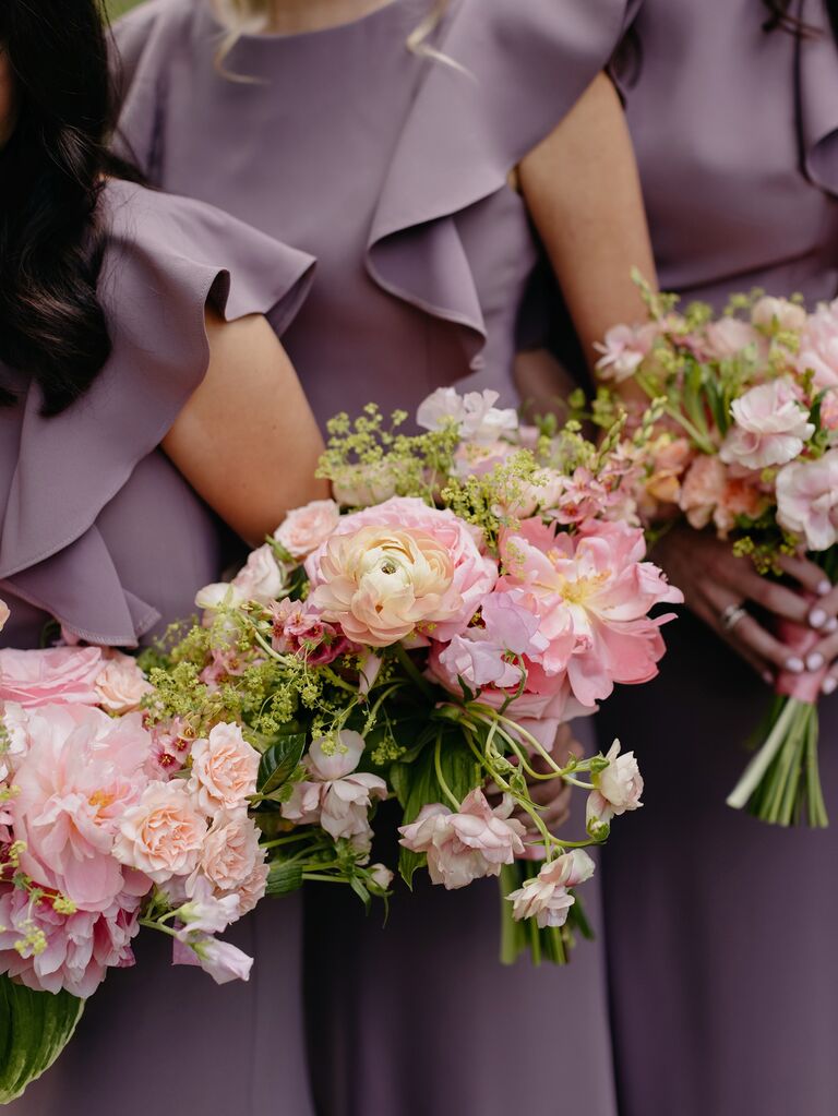 Bridesmaids hold pale pink and green bouquets.