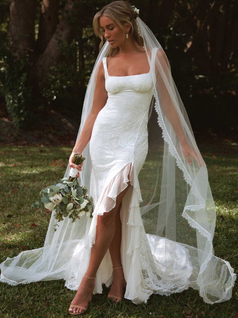Model wears a beautiful mermaid-style wedding gown with a ruffled hem. 