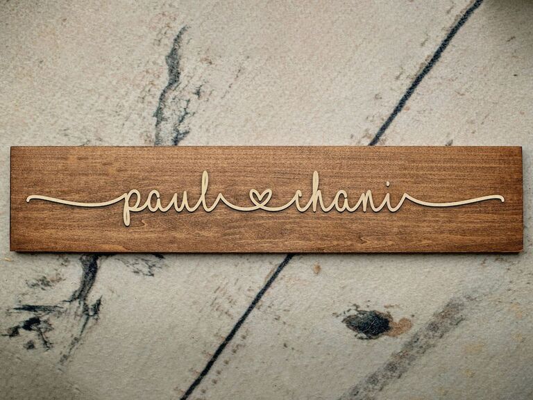Cool wedding gift wooden sign with couple's names joined by a heart in raised lettering