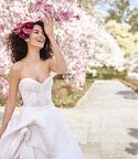 Bride avec fleur dans les cheveux à côté d'un arbre fleuri