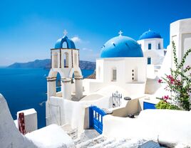 Scenic view of traditional cycladic white houses and blue domes in Oia village, Santorini island, Greece