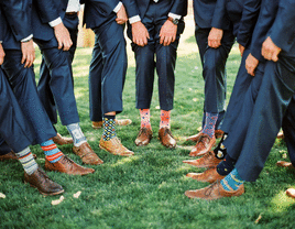 Groom and groomsmen wearing mismatched patterned wedding socks