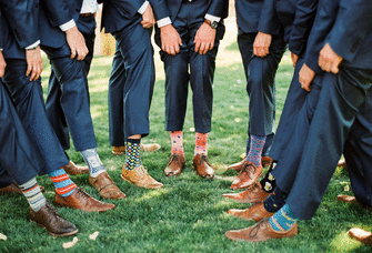 Groom and groomsmen wearing mismatched patterned wedding socks