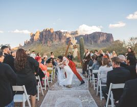 Couple kissing in the middle of the ceremony aisle with a mountain backdrop