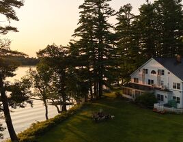 Outside ariel view of property overlooking the water at sunset