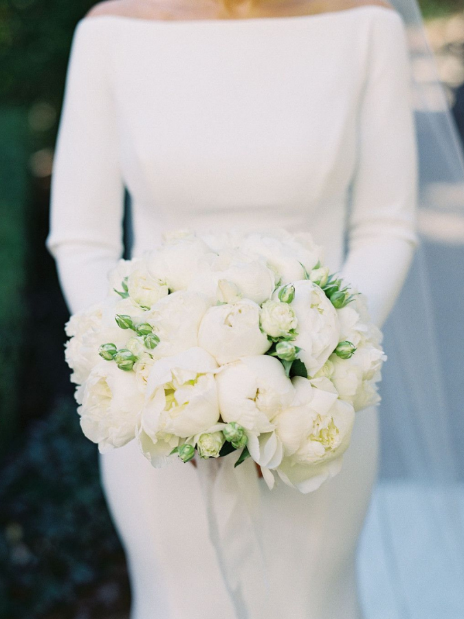 Bride holding white peony bouquet