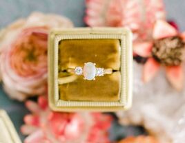 Diamond engagement ring in ring box on top of pink flowers