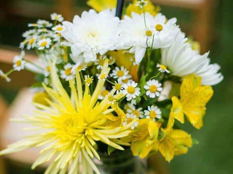 A wedding aisle flower arrangement with chamomile flowers and chrysanthemums