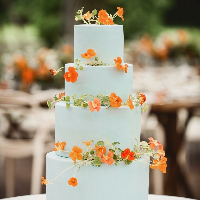 four-tier sky blue cake with orange nasturtiums