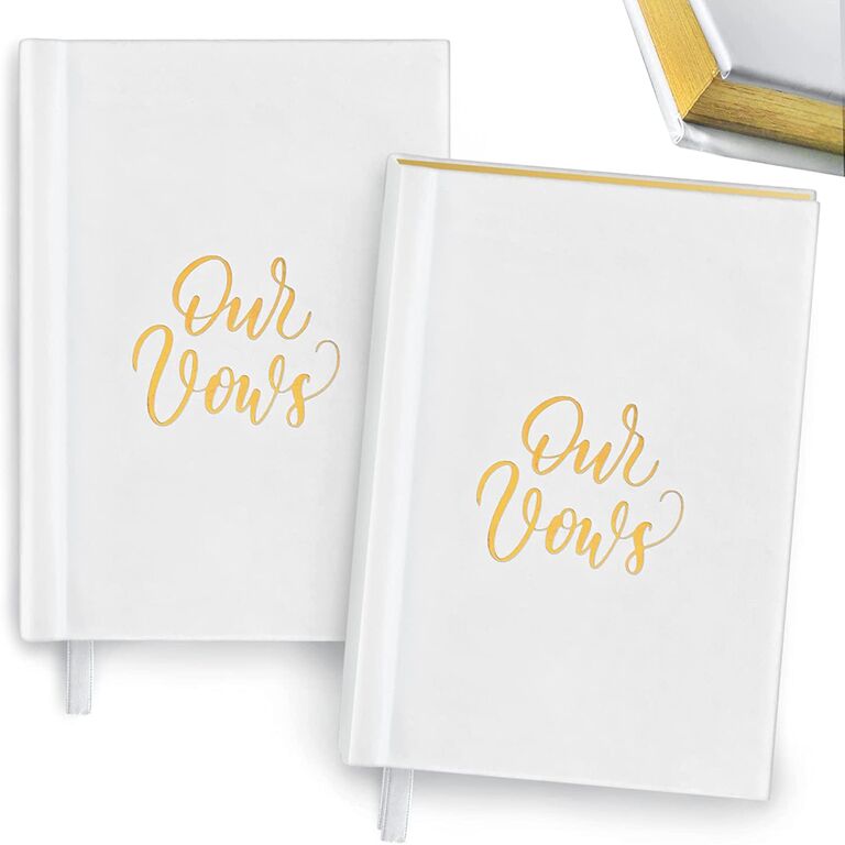 plain white hardcover vow books with our vows written in gold lettering on the front