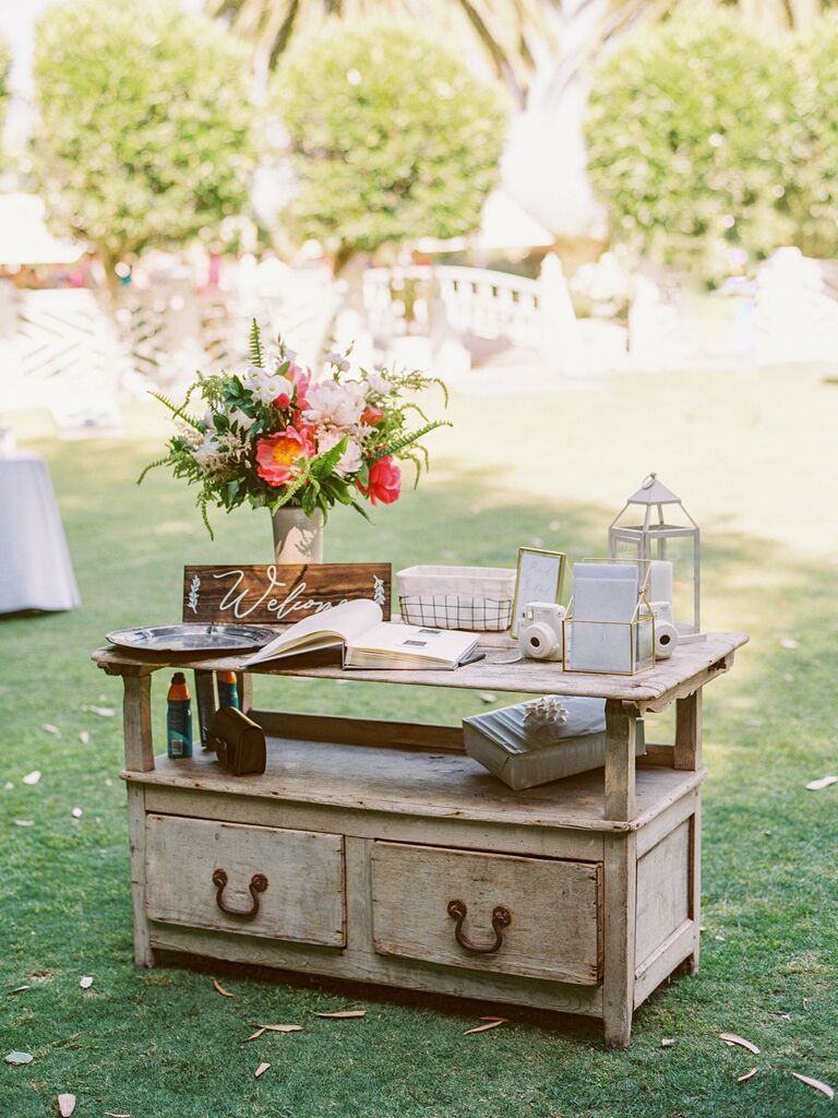 vintage wooden sideboard repurposed as wedding gift table with guest book and welcome sign