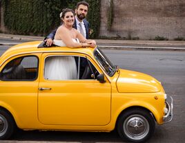 Couple standing thru sunroof of car