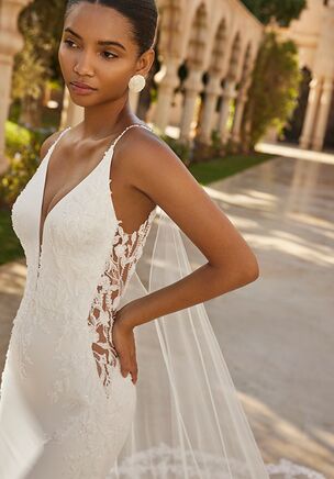 Long two-piece mermaid wedding dress. Made of bi-stretch crepe with lace and beaded bodice, deep neckline, V-shaped back, lace train, and cape.