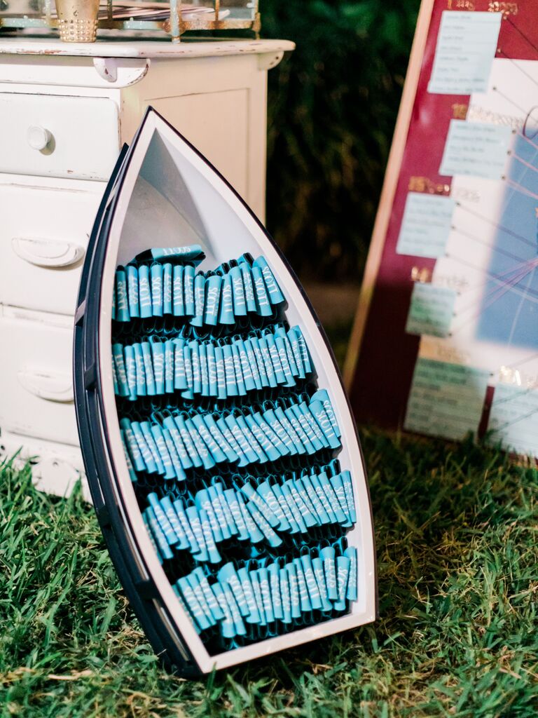 beach wedding favor display with drink koozies stacked in miniature row boat
