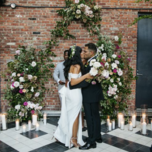 couple kissing at the altar with exposed brick background and candles