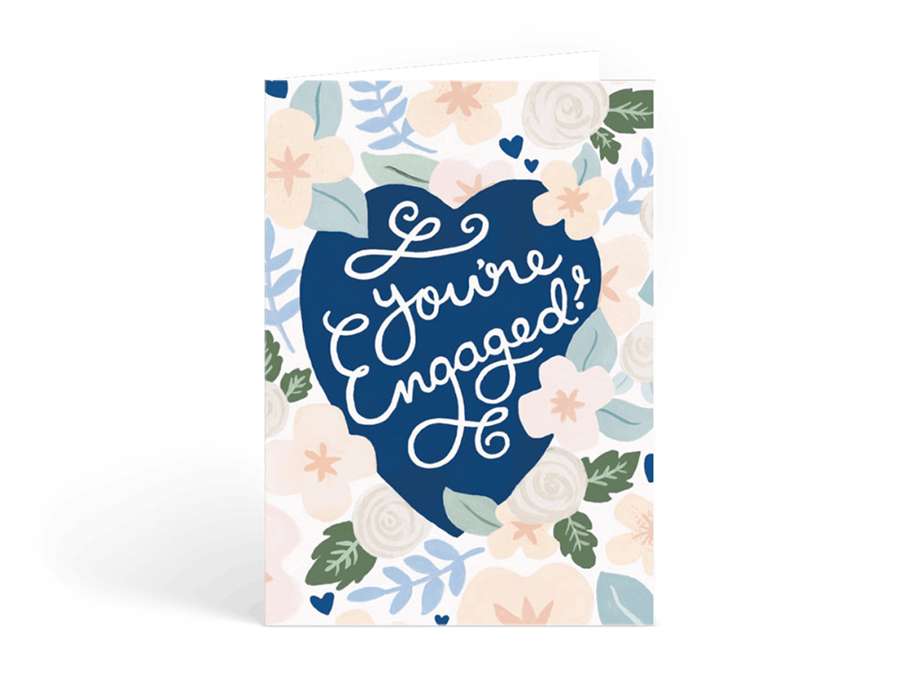 'you're engaged!' in white script in blue heart with pink flowers