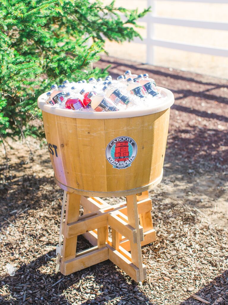 wooden barrel bucket with bottles of kombucha in ice