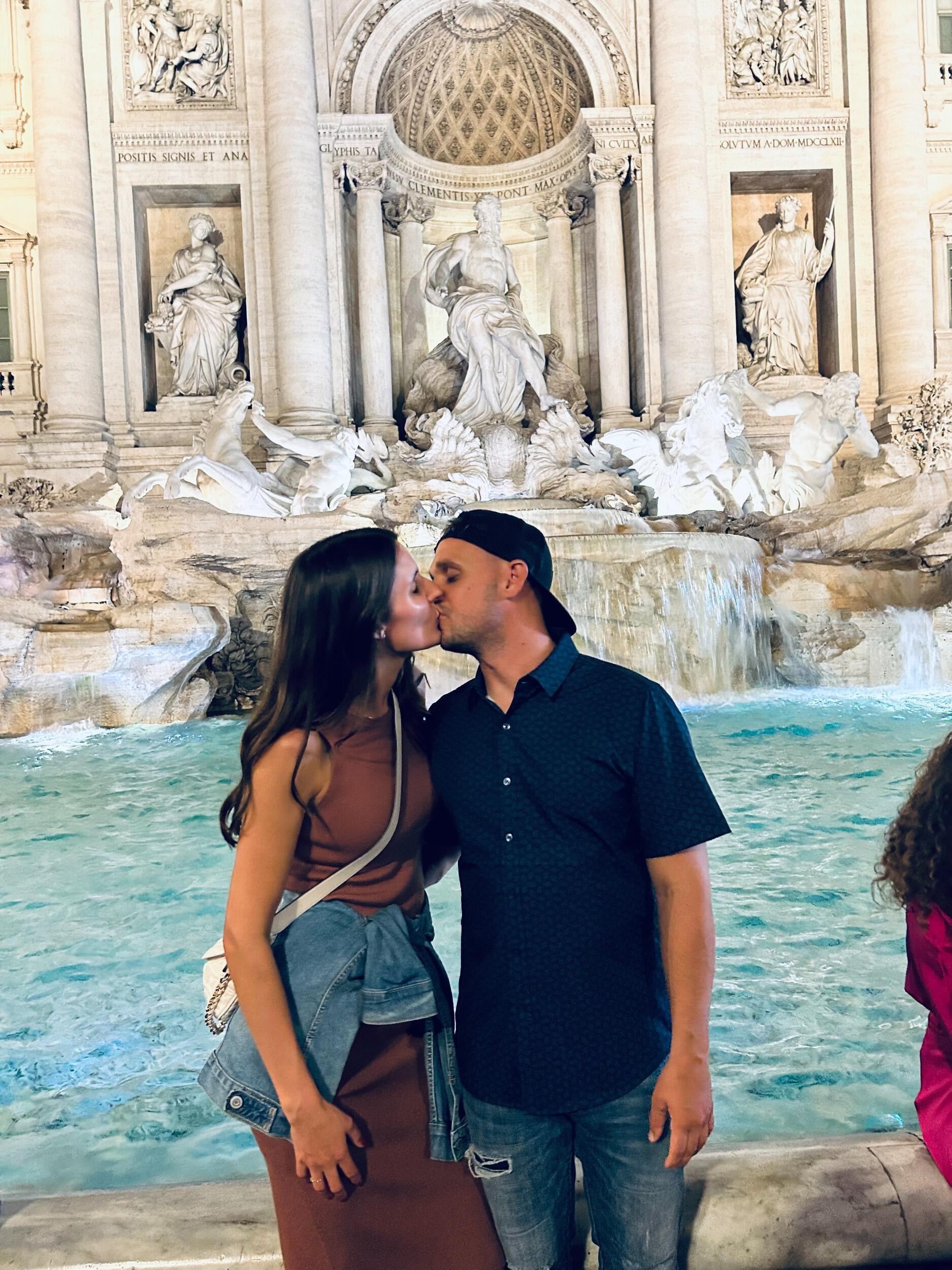 Kissing in front of the Trevi Fountain in Italy