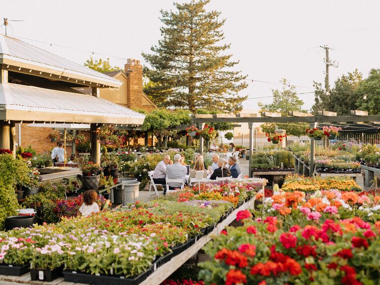 Beautiful garden with flowers and plants with people enjoying outdoor dining
