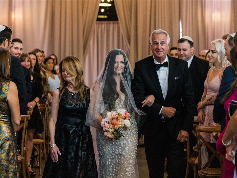 Jamie Milne walking down the aisle escorted by her parents