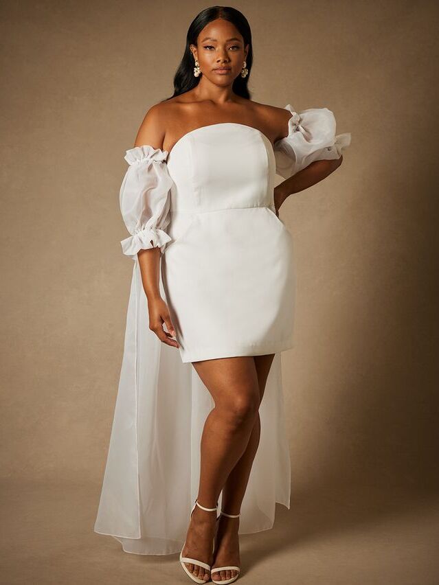 Short white mini dress with puffed sleeved and a tulle cape. 