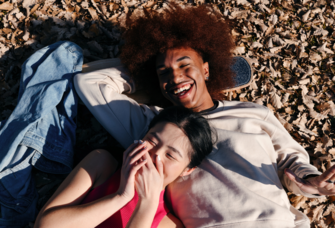 Couple laying on leaves in fall, best fall captions