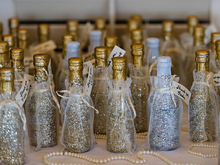 NYE wedding favors miniature champagne bottles covered in gold and silver glitter