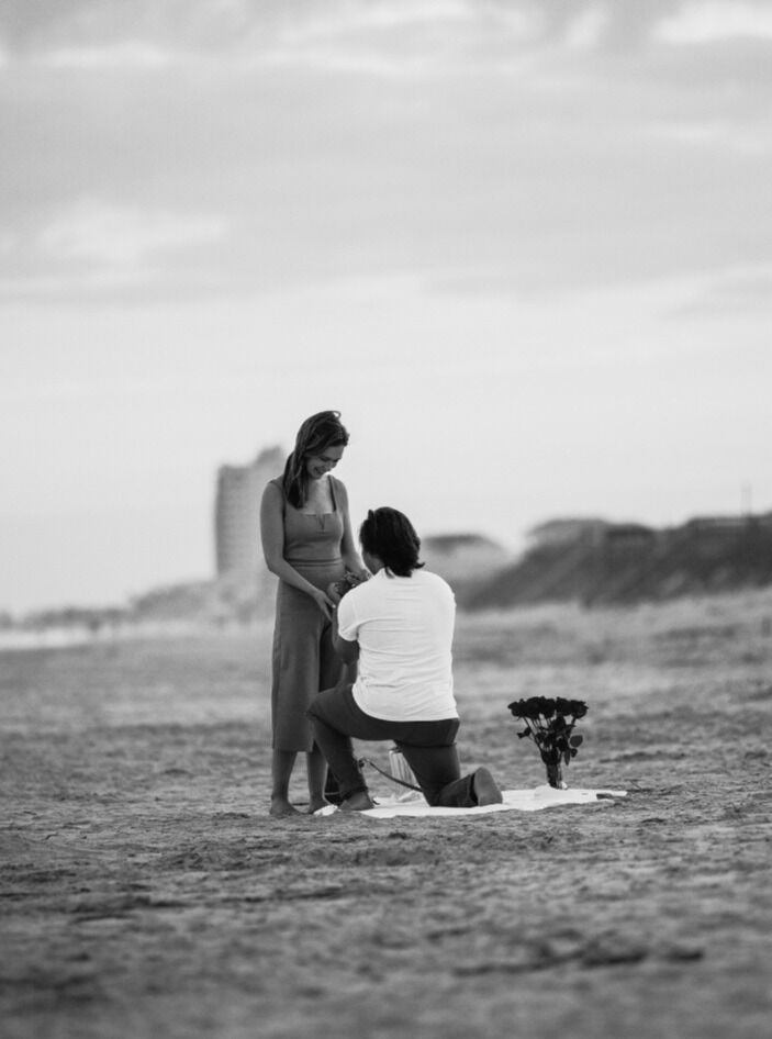 Trevor planned the most beautiful proposal at Ocean Isle. He planned for us to go to dinner so we were all dressed up and asked me to take a walk on the beach after. With the help of a few friends and a photographer, we returned to a beautiful set up of roses and candles and champagne where Trevor dropped to one knee and proposed. 
