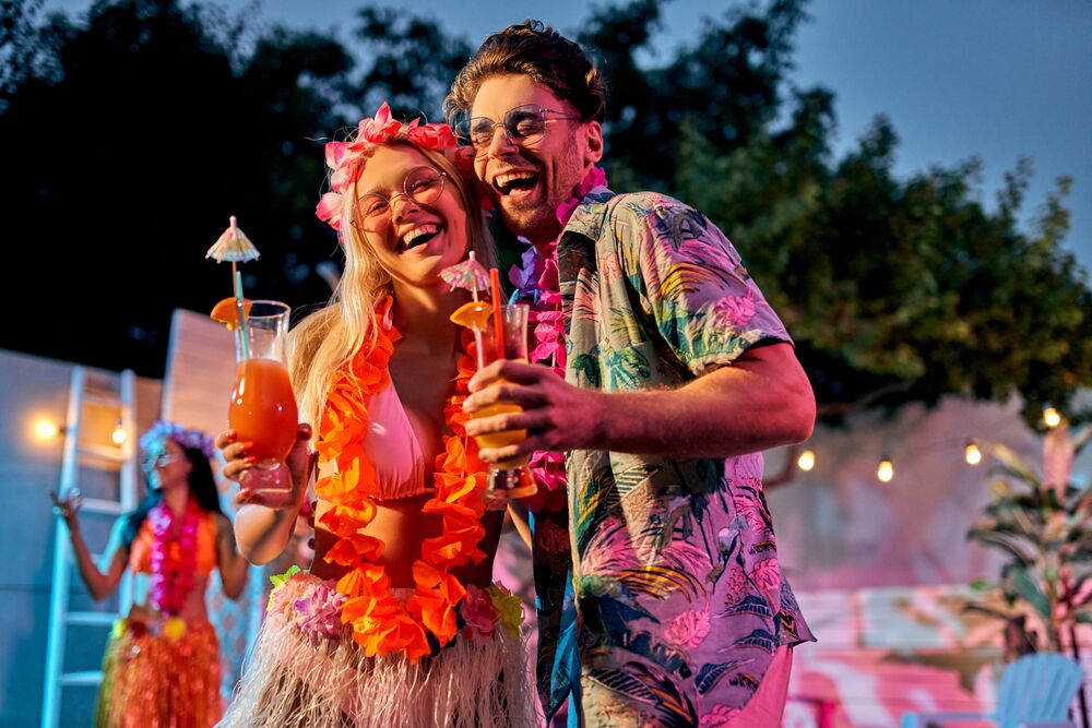 two young people in tropical luau themed outfits